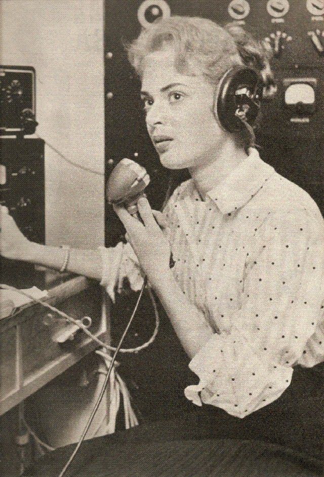 Une femme au casque, un combiné à la main, années 1950